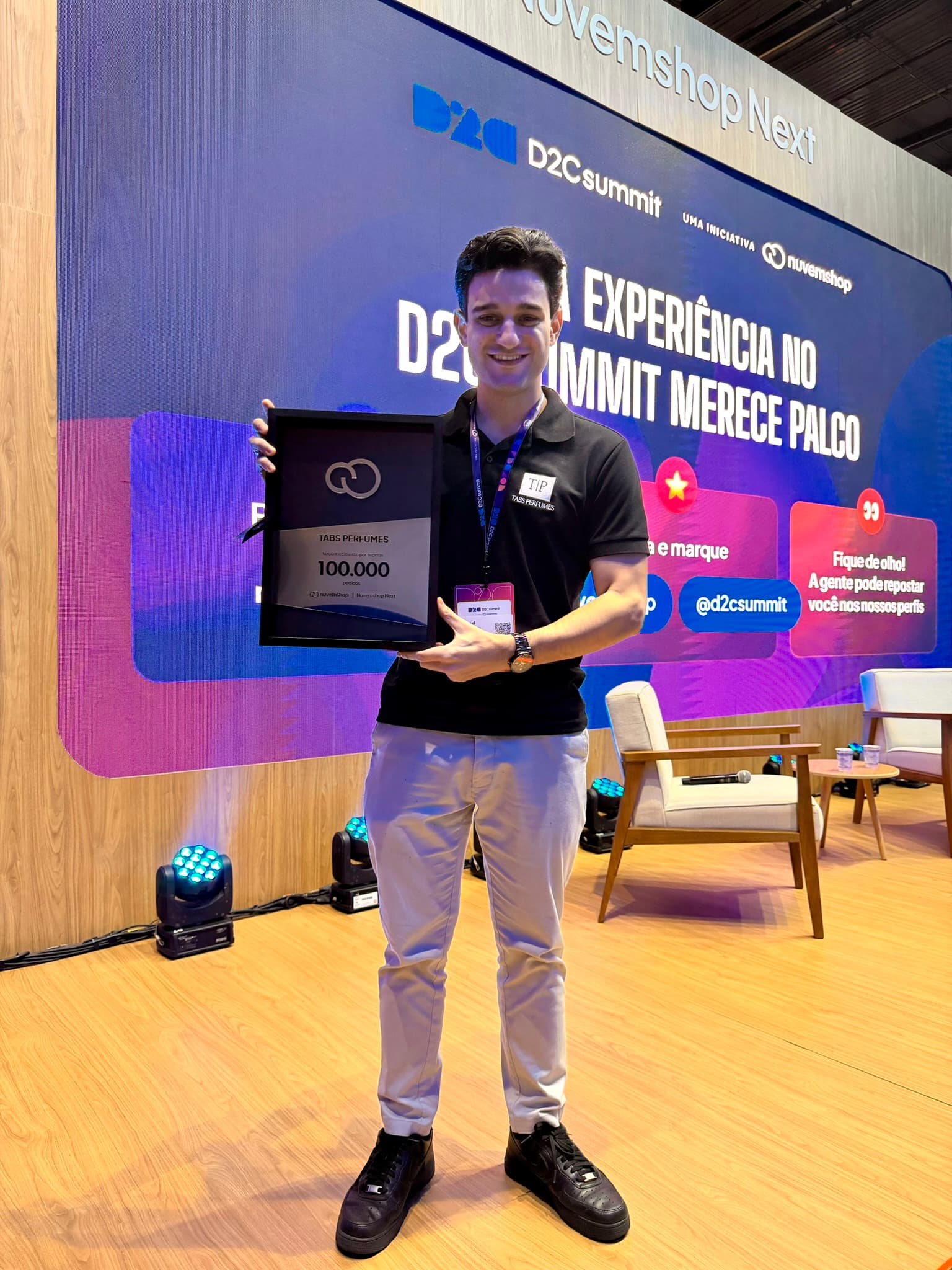 Gabriel Tabchoury no D2C Summit segurando a placa da Nuvemshop de 100 mil pedidos da Tabs Perfumes